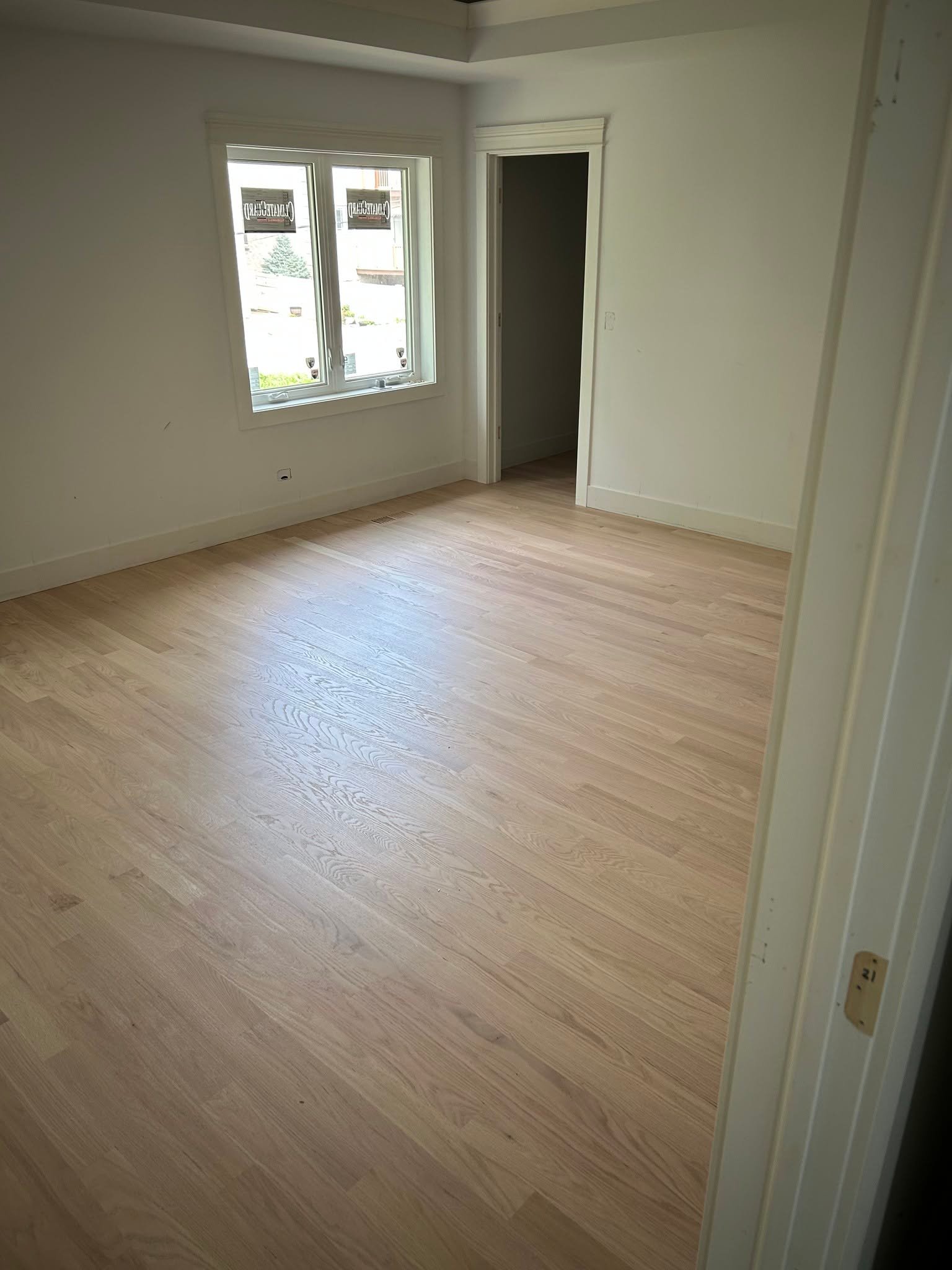 Finished hardwood flooring in an empty room after installation