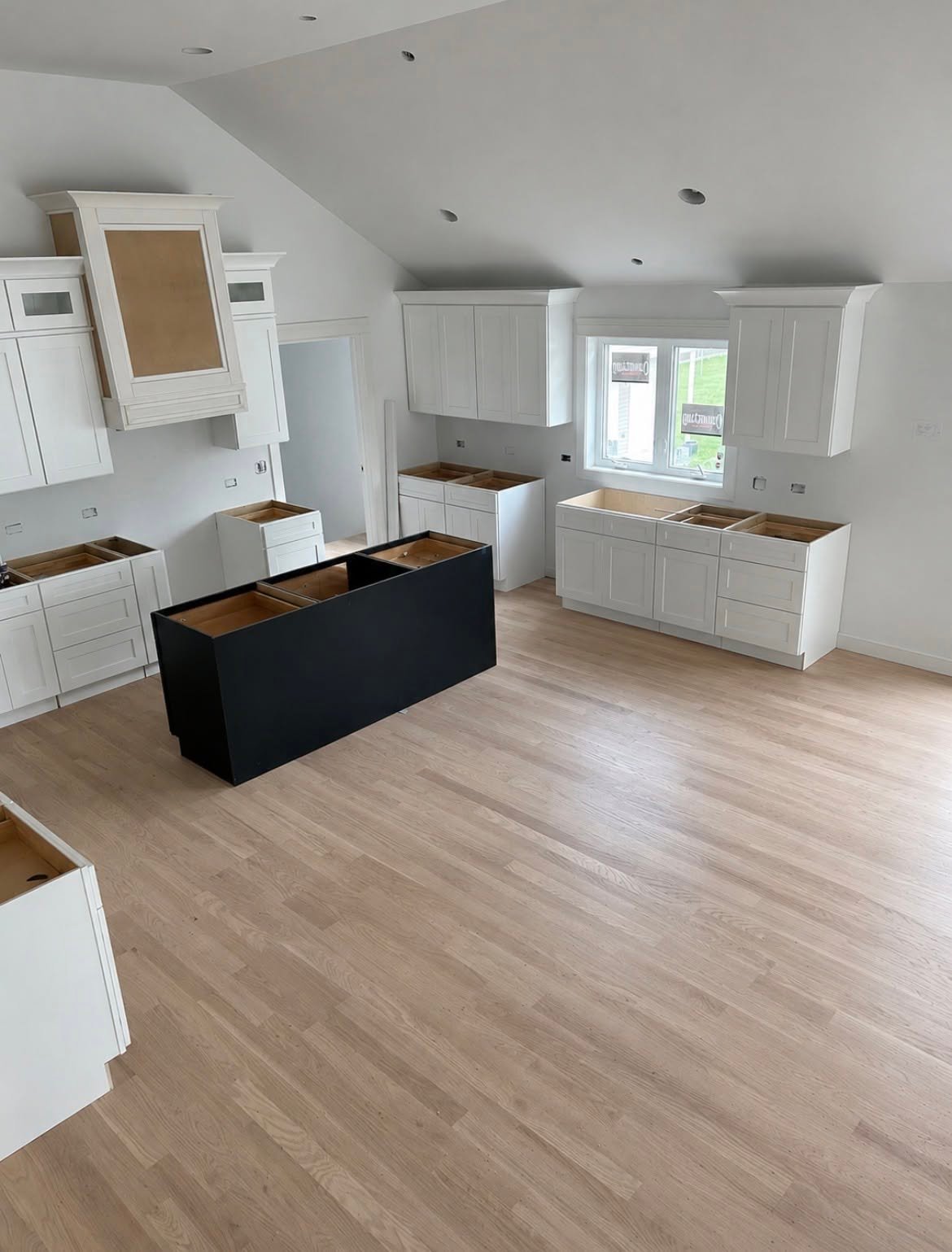 Hardwood flooring installed through an open kitchen with island